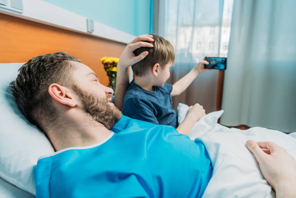 father and son taking selfie at ward - Photo, Image