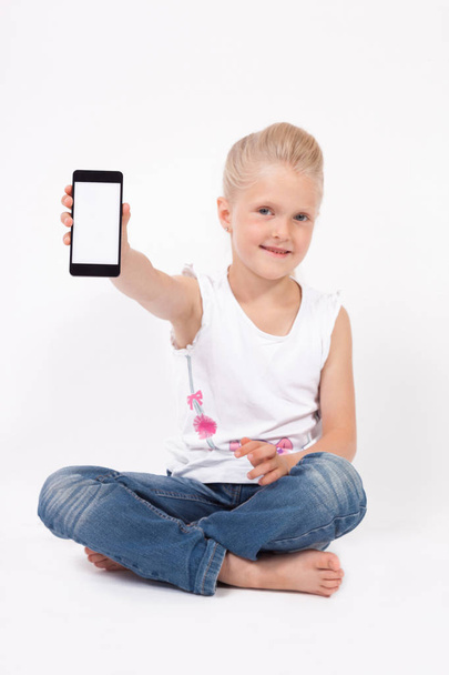 Schoolgirl in a shirt with phone - Foto, afbeelding