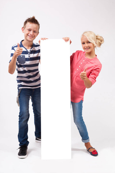 Happy schoolchildren with white poster - Foto, Bild