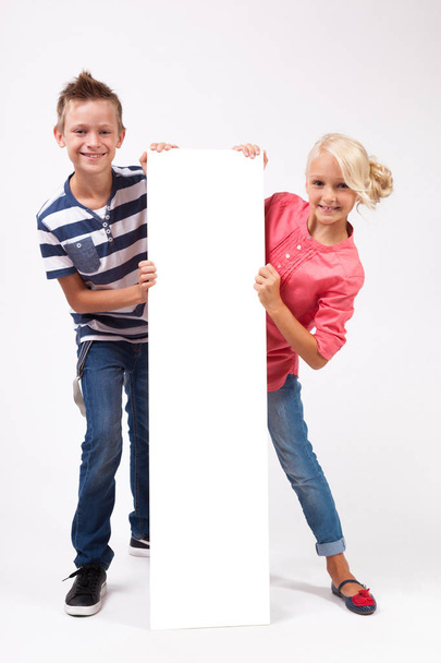 Niños felices con póster blanco
 - Foto, Imagen
