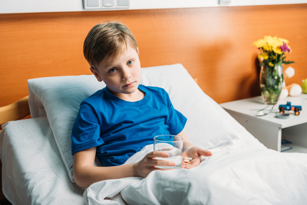 boy with glass of water and medicines  - Foto, afbeelding
