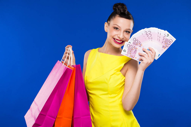 brunette girl with shopping bags and money - Valokuva, kuva