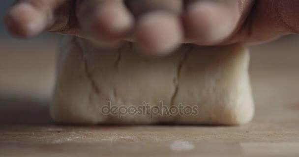 slow motion closeup of black man hand takes off a roll of dough from focus to blur - Кадры, видео