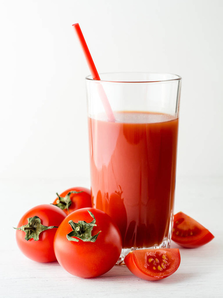 Jus de tomate en verre et tomates fraîches sur table en bois blanc
. - Photo, image