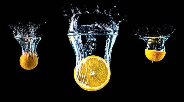 Composition of three oranges falling into water close-up, macro, splash water, bubbles, isolated, black background. Big large size. - Foto, Imagen