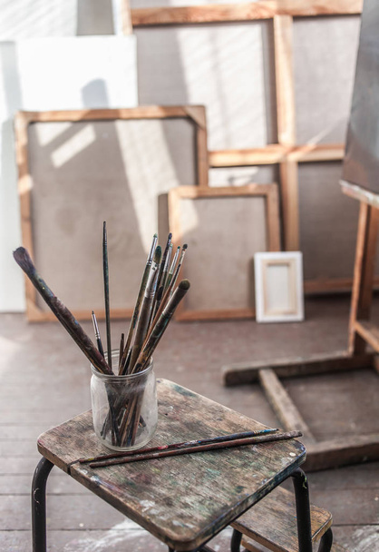 paintbrushes in glass on stool - Fotó, kép