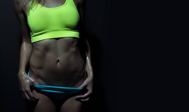 Nahaufnahme sexy athletischer weiblicher Bauchmuskeln in Sportbekleidung nach dem Training - Foto, Bild