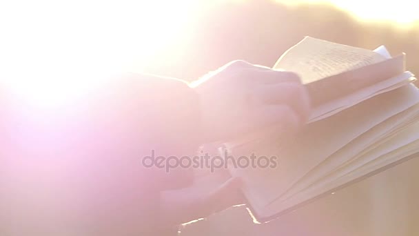 Personleafing za pośrednictwem stron książki na zewnątrz w słońcu, zamknąć w zwolnionym tempie - Materiał filmowy, wideo