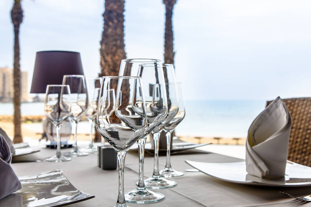 Kieliszki do wina stoją na stole z Kamieńczy biały obrus - Zdjęcie, obraz