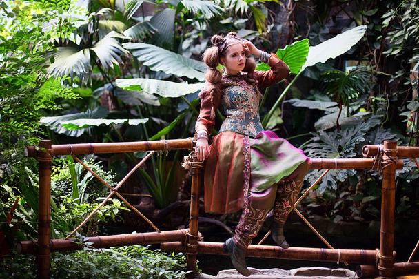 Girl in ethnic clothes in tropical garden - Fotoğraf, Görsel