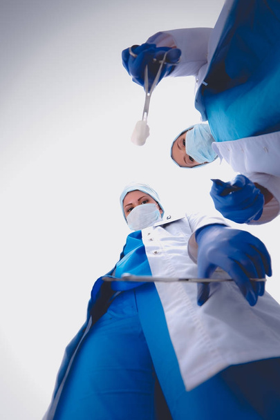Surgeons team, woman wearing protective uniforms,caps and masks - Fotoğraf, Görsel