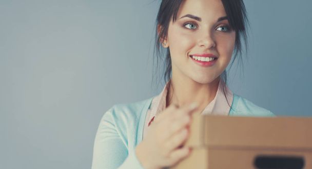 Portrait of pretty woman holding a box - Foto, imagen