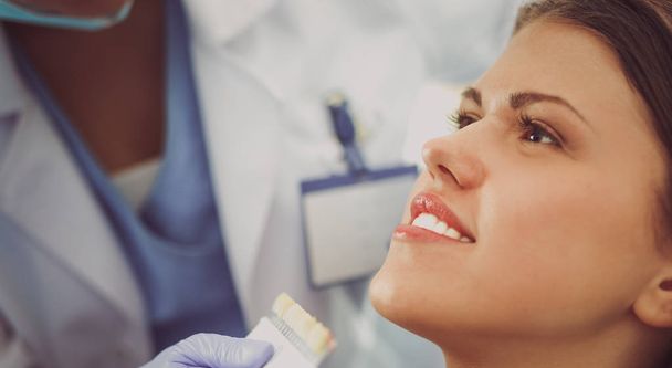 Woman dentist working at her patient  teeth - Foto, afbeelding