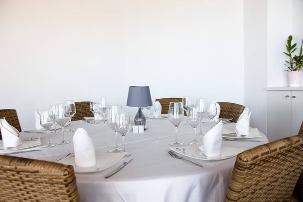The wine glasses stands on a round table covered with a white ta - Foto, immagini