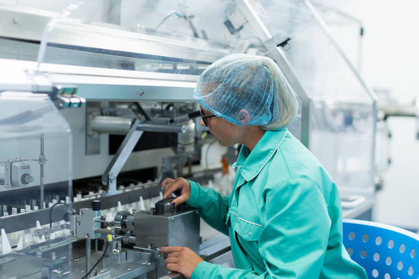 wetenschapper is permanent in de buurt van machine in fabriek - Foto, afbeelding