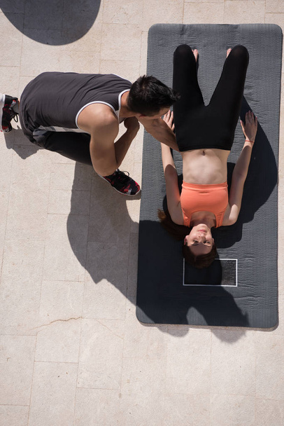 vrouw met personal trainer ochtend yoga doen  - Foto, afbeelding