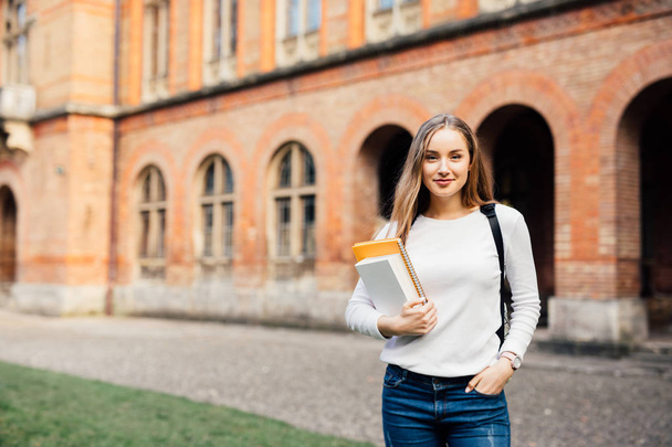 glückliche Schülerin mit Schultasche und Notizbüchern im Freien - Foto, Bild