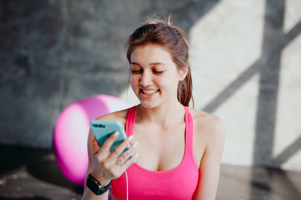 woman at gym using mobile phone - Foto, afbeelding