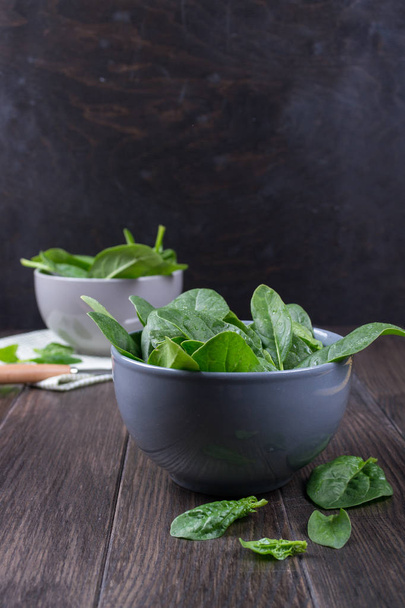 Fresh garden organic spinach in bowl  on rustic background ready for salad.  - Foto, Imagen
