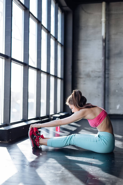 teenage girl stretching in gym - Photo, image