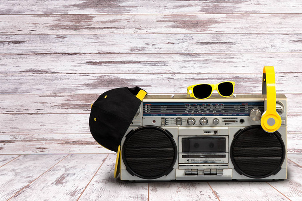 Vintage audio player with headphones.fashionable cap and sunglasses.Vintage style .The concept of the music Hip hop style. - Fotó, kép