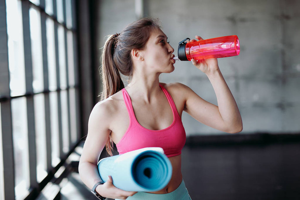 Young athletic woman drinking water - Фото, зображення
