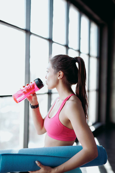 Young athletic woman drinking water - 写真・画像