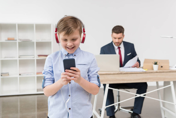 niño escuchando música en la oficina
 - Foto, Imagen