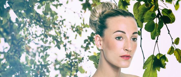 Blonde pretty girl portrait with hair bun and green leaves, letterbox - Foto, Imagem