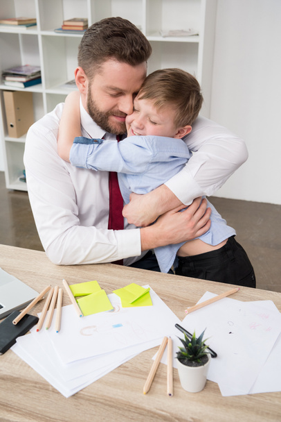 Empresario abrazándose con hijo
 - Foto, Imagen