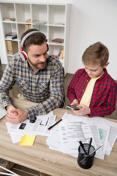 Businessman in headphones with son - Photo, Image