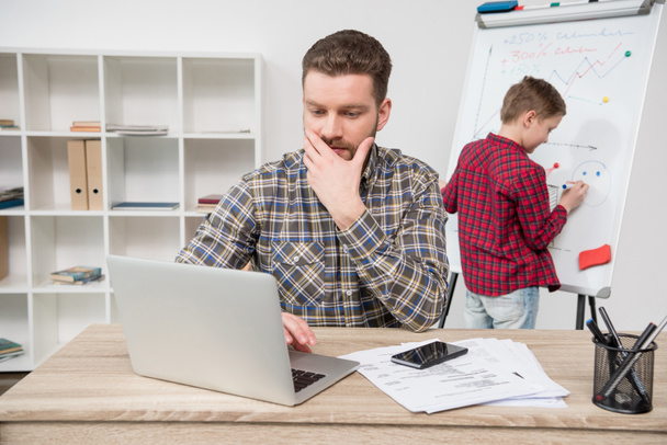freelancer con hijo en la oficina
 - Foto, Imagen