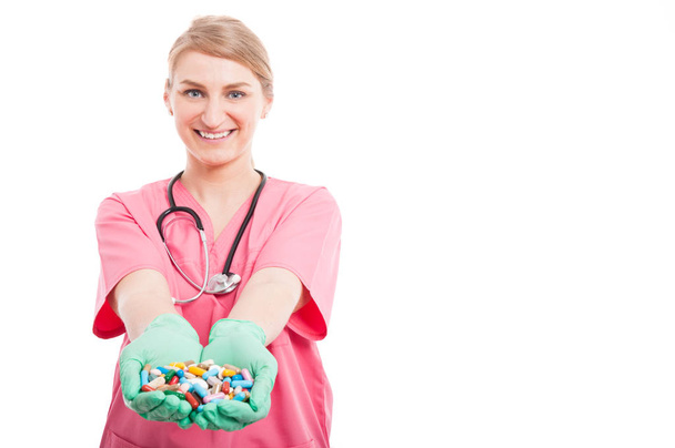 Vriendelijke medisch verpleegkundige dame glimlachend weergegeven: veel pillen - Foto, afbeelding