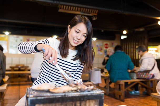 Женщина наслаждается барбекю из морепродуктов
 - Фото, изображение