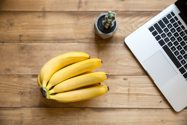 Ripe bananas and laptop  - Foto, afbeelding