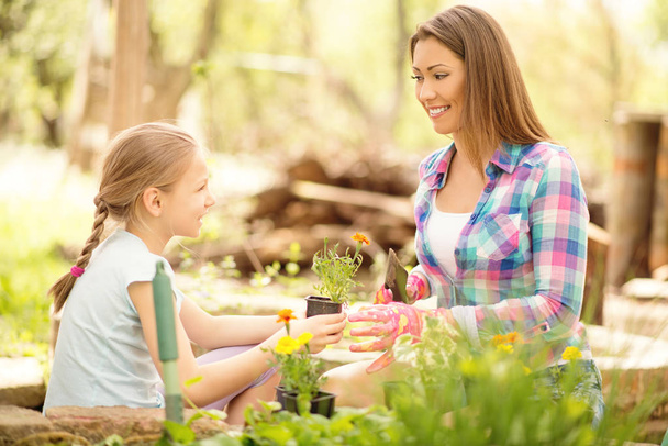 girl assisting her mother planting flowers - Photo, Image