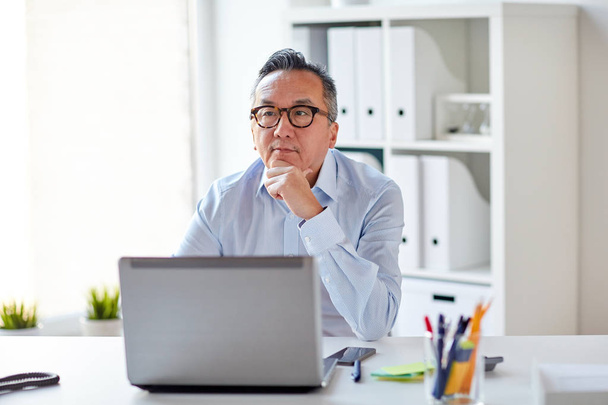 businessman in eyeglasses with laptop office - Фото, изображение