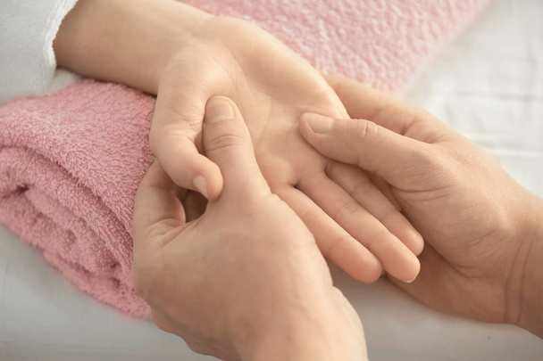 Young woman receiving hand massage - Fotografie, Obrázek