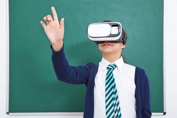 Schoolgirl with virtual reality glasses in classroom - Valokuva, kuva