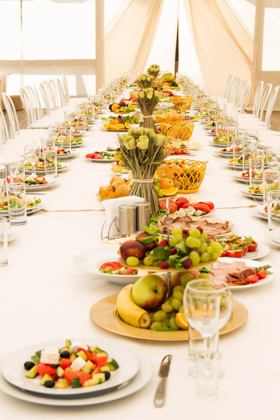Довгий святковий стіл з їжею
 - Фото, зображення