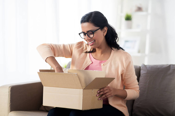 happy young indian woman with parcel box at home - Foto, imagen