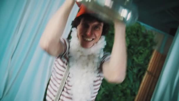 Radostné muž v kostýmu trpaslík zvedání staré unavené rozbité plechová tuba nad hlavou - Záběry, video