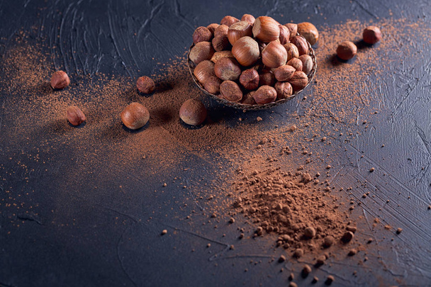 Hazelnut and cocoa powder in dark background.  - Fotografie, Obrázek