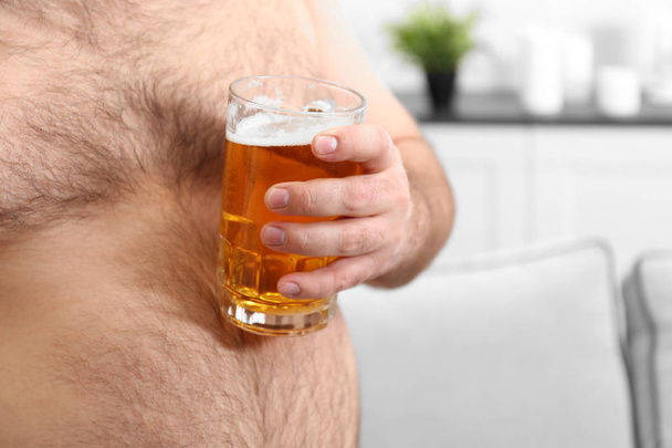 Man holding beer on big belly  - Valokuva, kuva
