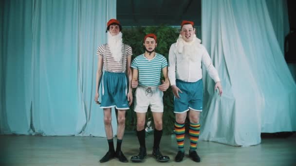Três homens engraçados vestidos como gnomos pulam simultaneamente, olhe para as mãos surpresas
 - Filmagem, Vídeo