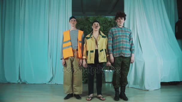 Três homens engraçados vestidos como trabalhadores da estrada sujos pulam simultaneamente na cena
 - Filmagem, Vídeo