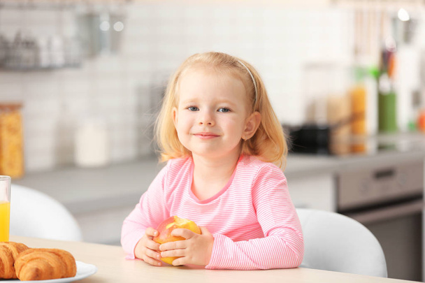 Cute little girl having breakfast at home - Foto, Bild