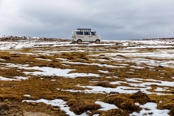 Oude van op een diepe sneeuw onder zware sneeuwval, de weg naar de gletsjer Fjallsarlon, Winter off-road rijden in IJsland - Foto, afbeelding