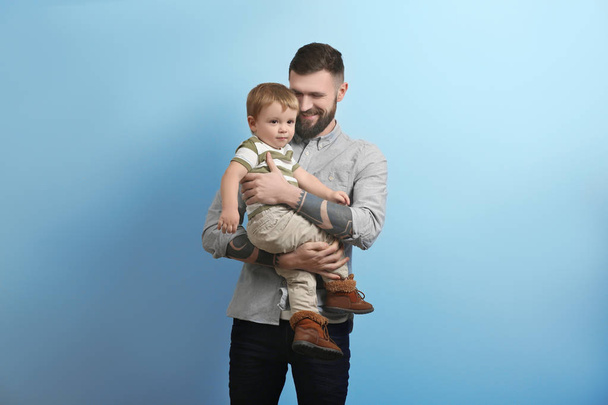 young man holding little boy - Фото, зображення