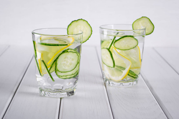 Cóctel refrescante de pepino, limonada, agua de desintoxicación en vasos sobre fondo blanco
.  - Foto, Imagen